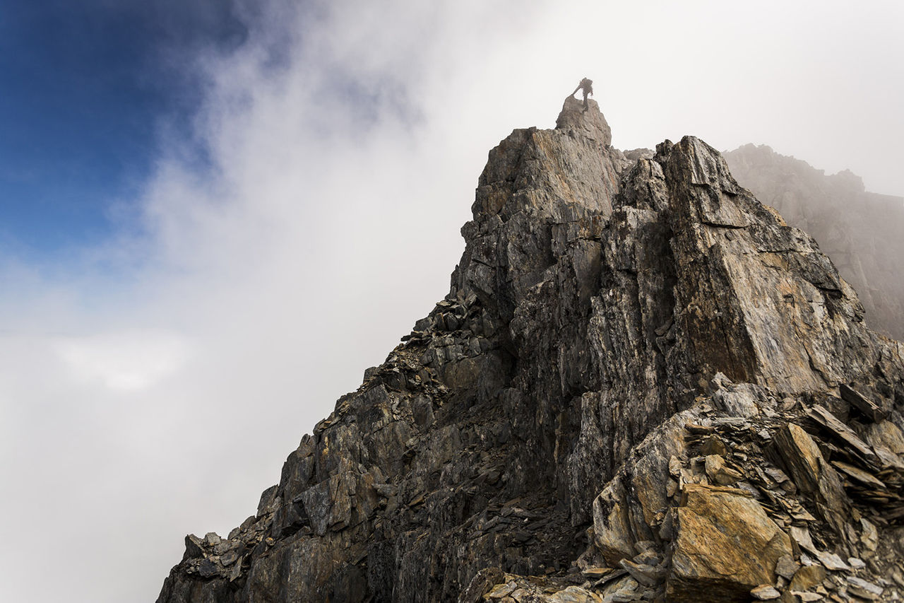 Low angle view of man climbing on mountain